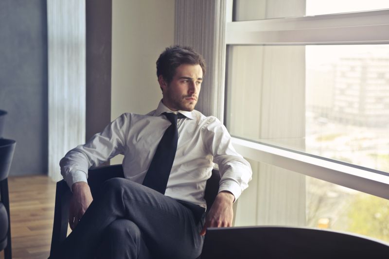 Thoughtful young professional looking out office window
