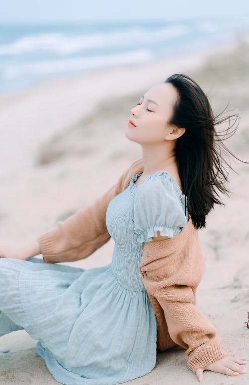 Tranquil Asian woman resting on seashore