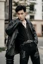 Stylish Asian model in leather jacket and cross on street
