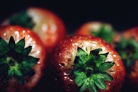 充满活力的特写镜头突出了新鲜草莓多汁的红色纹理和绿叶