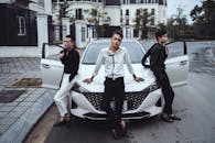 Confident stylish Asian men leaning on posh white car