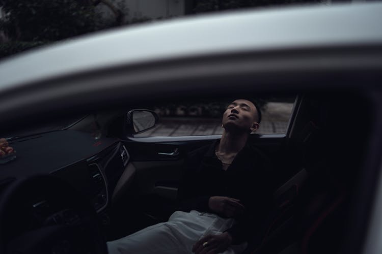 Young Ethnic Man Sleeping In Car