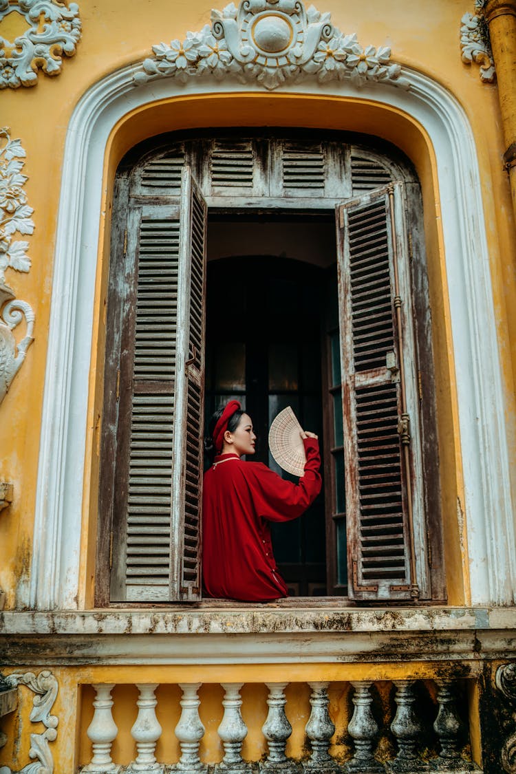 Woman In Red Clothes Sitting On The Window