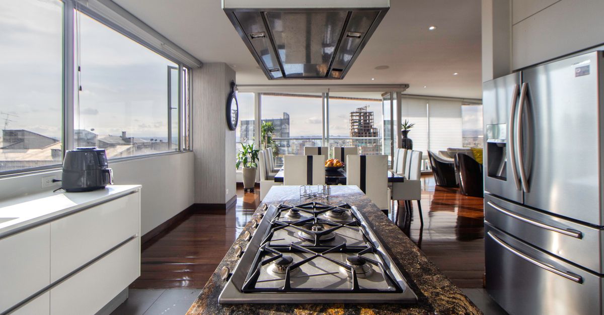 Spacious and sleek kitchen featuring stainless steel appliances and expansive city views, ideal for modern living.