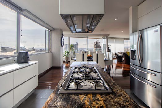 Spacious and sleek kitchen featuring stainless steel appliances and expansive city views, ideal for modern living.