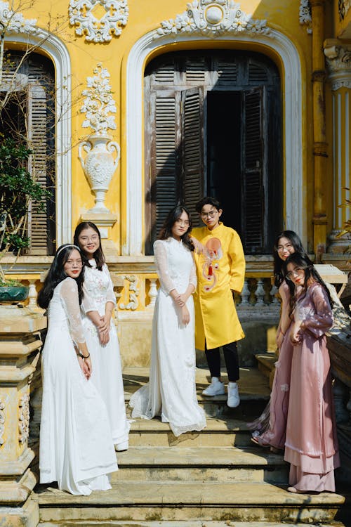 Free Positive Asian couple and bridesmaids in traditional clothes on doorsteps Stock Photo