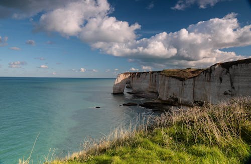 Rocky Cliff on a Peaceful Ocean During Daytime