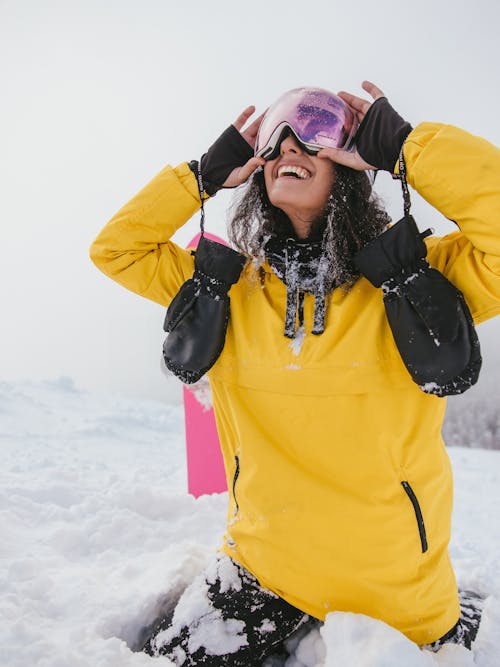 Woman in Yellow Jacket and Purple Goggles on Snow Covered Ground