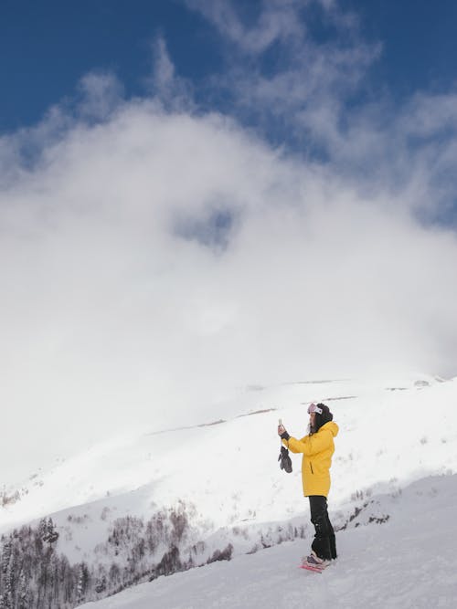 Free Person in Winter Clothing Standing on Snowy Mountain Stock Photo