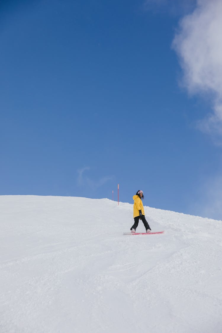 Woman In Yellow Jacket Snowboarding