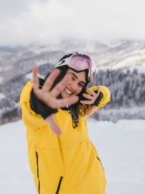 Smiling Woman in Yellow Jacket and Ski Goggles