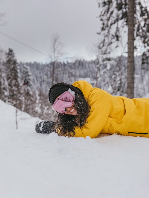 Woman in Yellow Jacket Lying on Snow