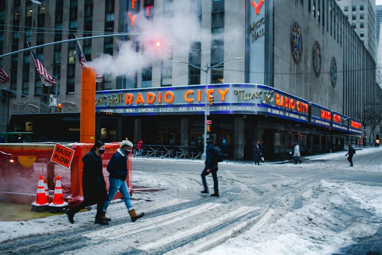 Anonymous People Walking In Snowy City During Coronavirus Pandemic