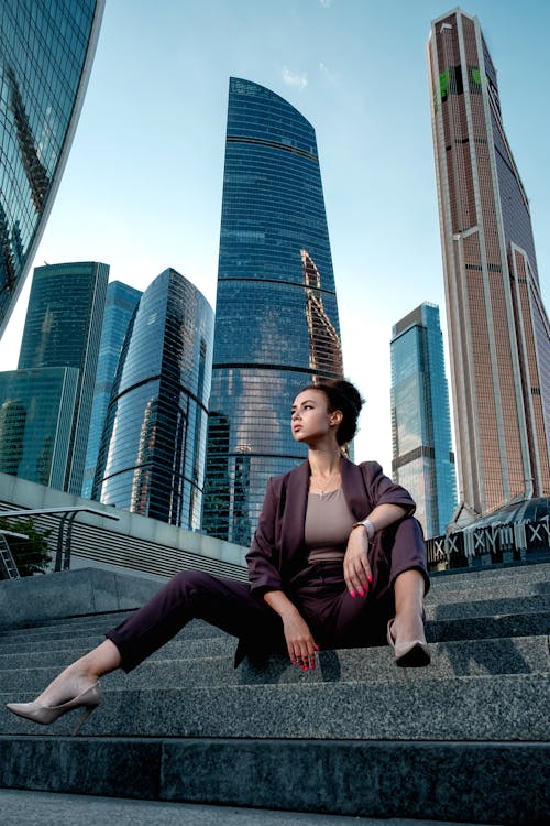 Woman in a Smart Casual Attire Sitting on a Concrete Stairs in the City Area