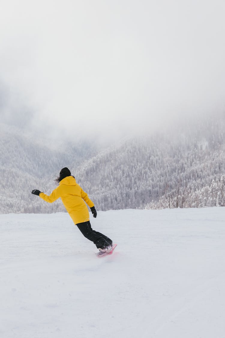 Woman In Yellow Hoodie Snowboarding