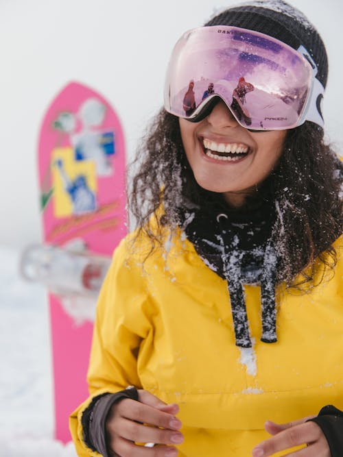 Free Woman in Yellow Jacket and Purple Goggles Smiling to the Camera Stock Photo