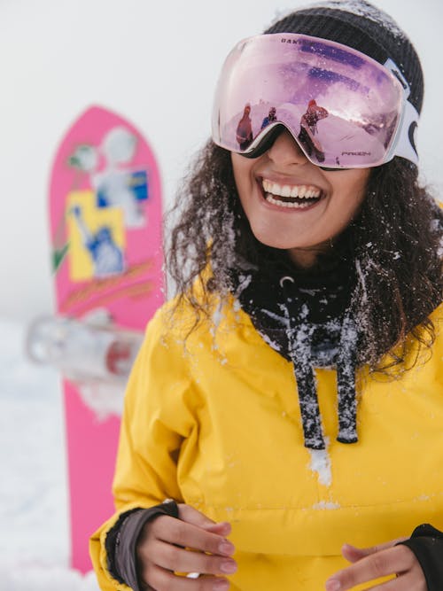 Woman in Yellow Jacket and Purple Goggles Smiling to the Camera