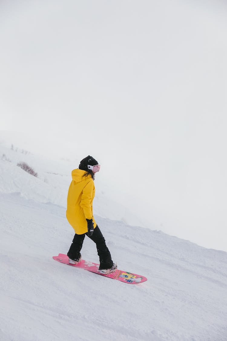 Woman In Yellow Hoodie Snowboarding