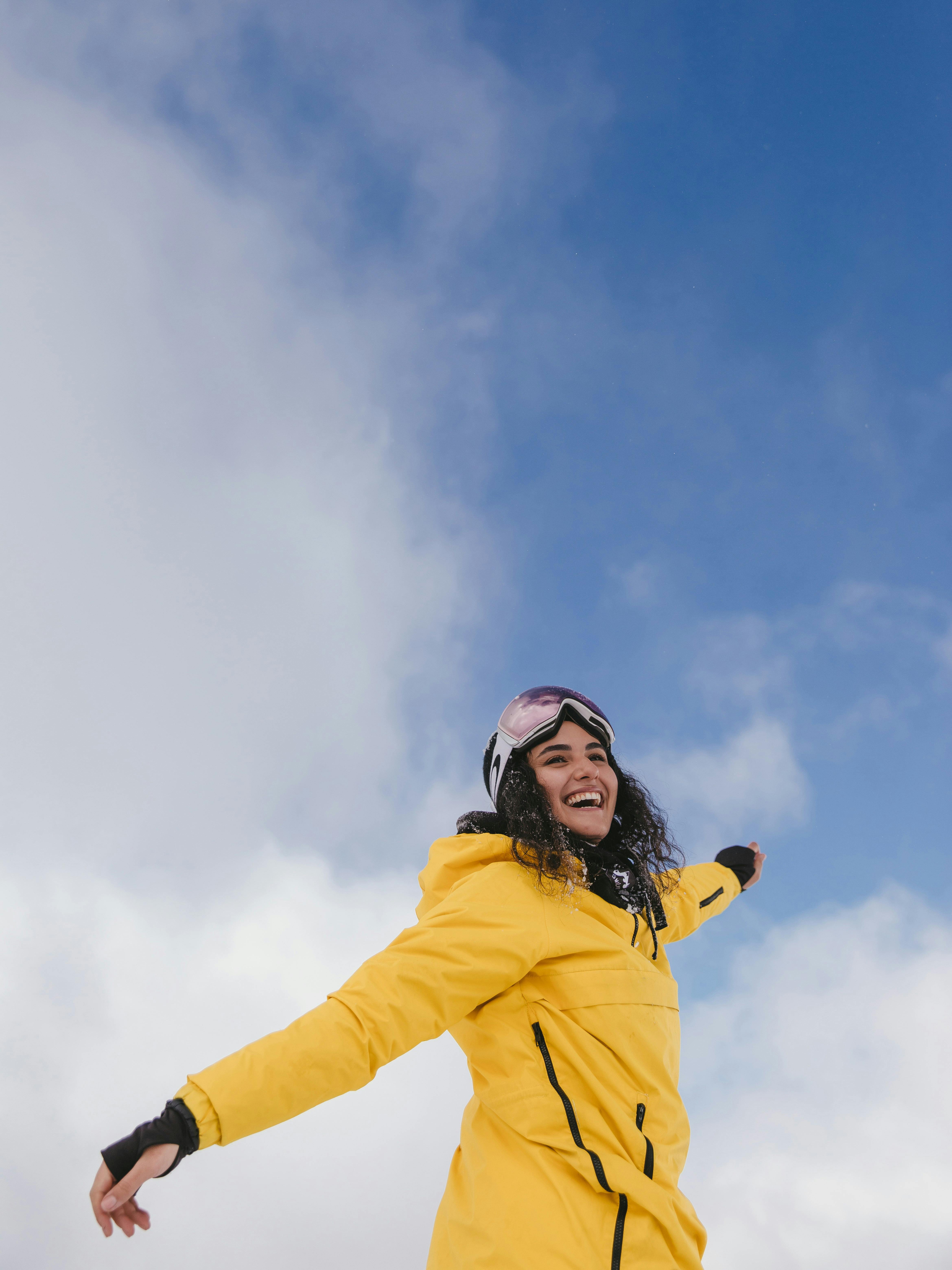 Woman in Yellow Jacket Stretching Arms · Free Stock Photo