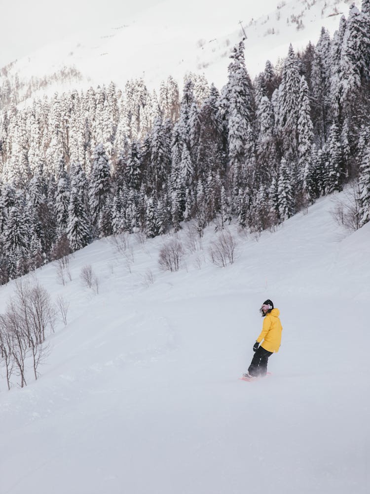 Woman In Yellow Hoodie Snowboarding