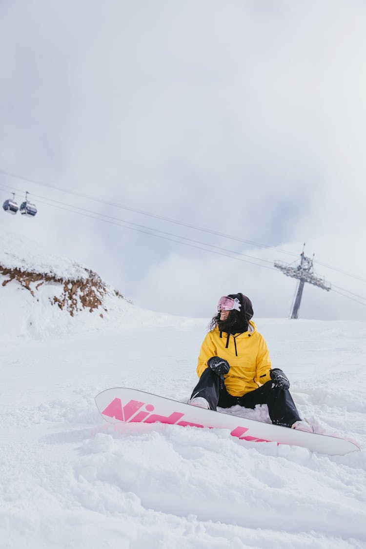 Woman In Yellow Hoodie Snowboarding