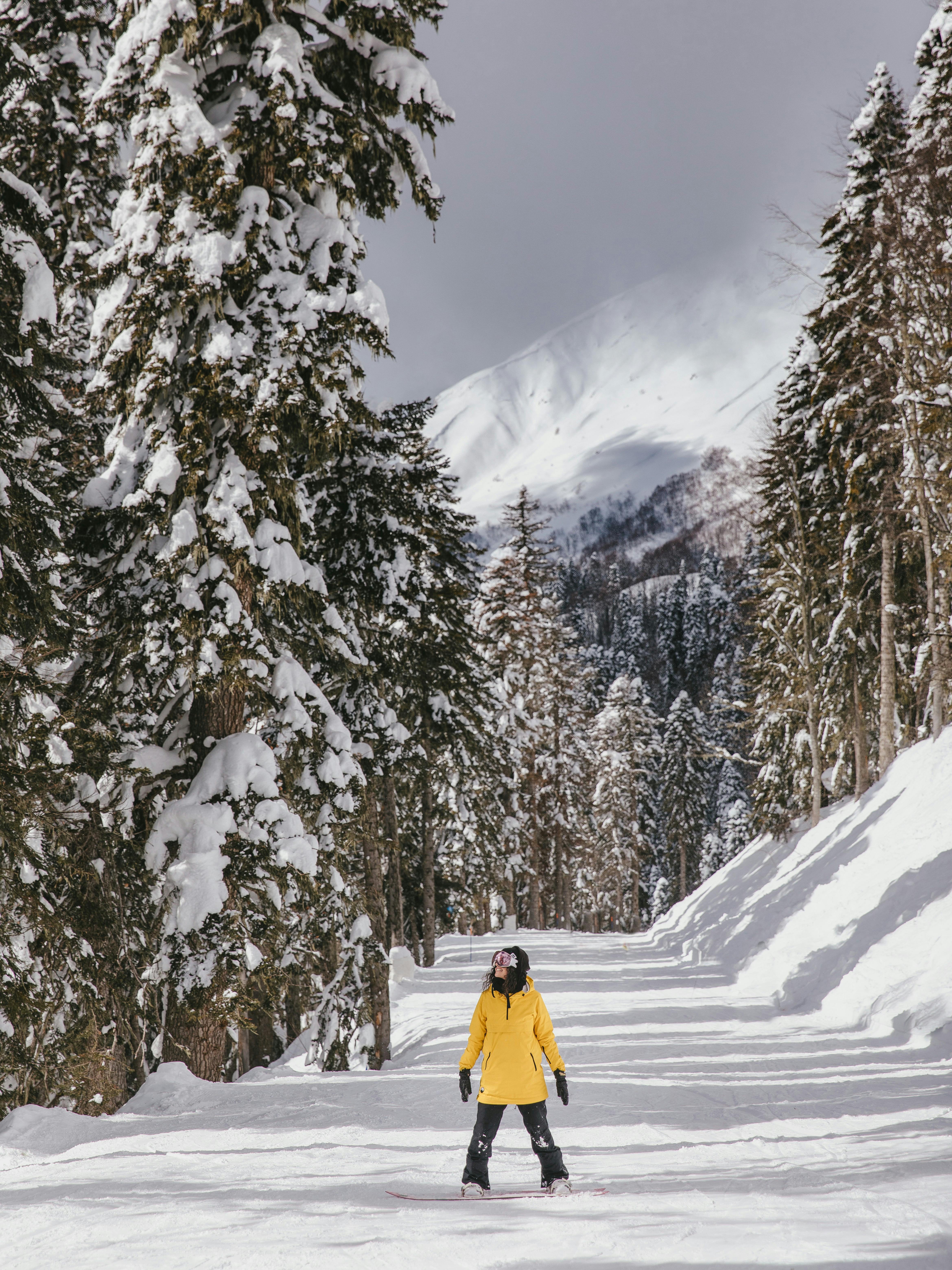 a person in yellow jacket snowboarding