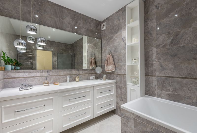 Modern bathroom with a double vanity, large mirror, and bathtub