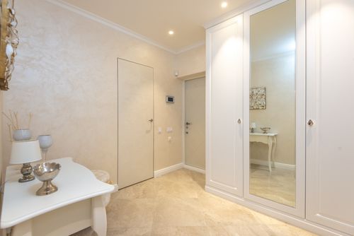Free Lamp and vases placed on table in front of wardrobe in spacious corridor on classic styled apartment Stock Photo