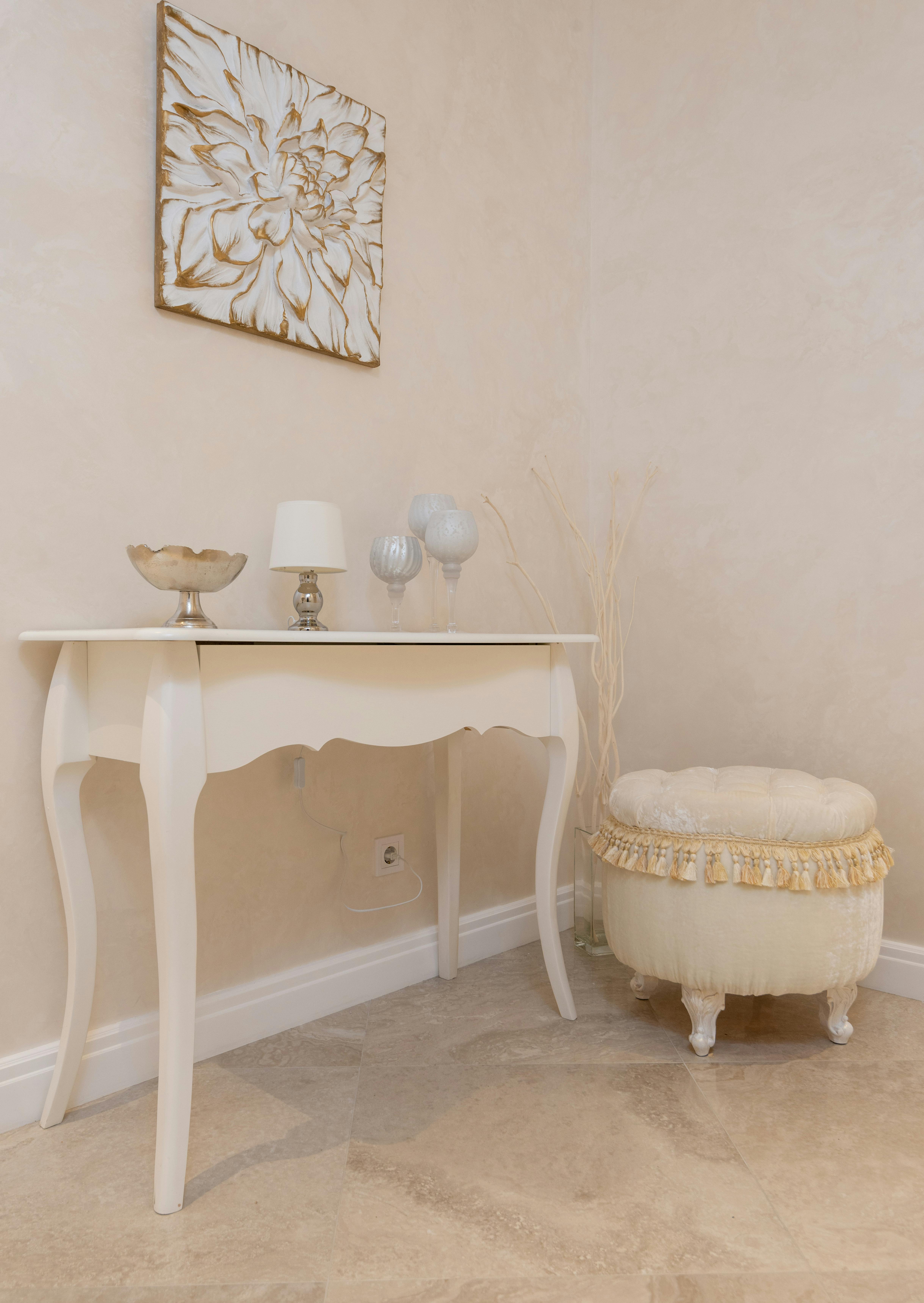 white table near soft stool in apartment decorated with picture