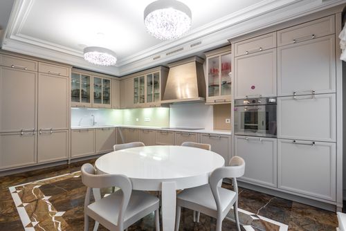 Free Stylish kitchen interior design featuring a round dining table and sleek cabinetry. Stock Photo