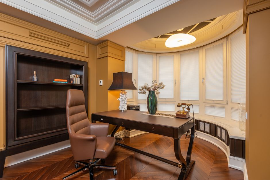Dark walnut modular boss cabin furniture arranged in an L-shape executive office with visitor seating, discussion table, and layered lighting