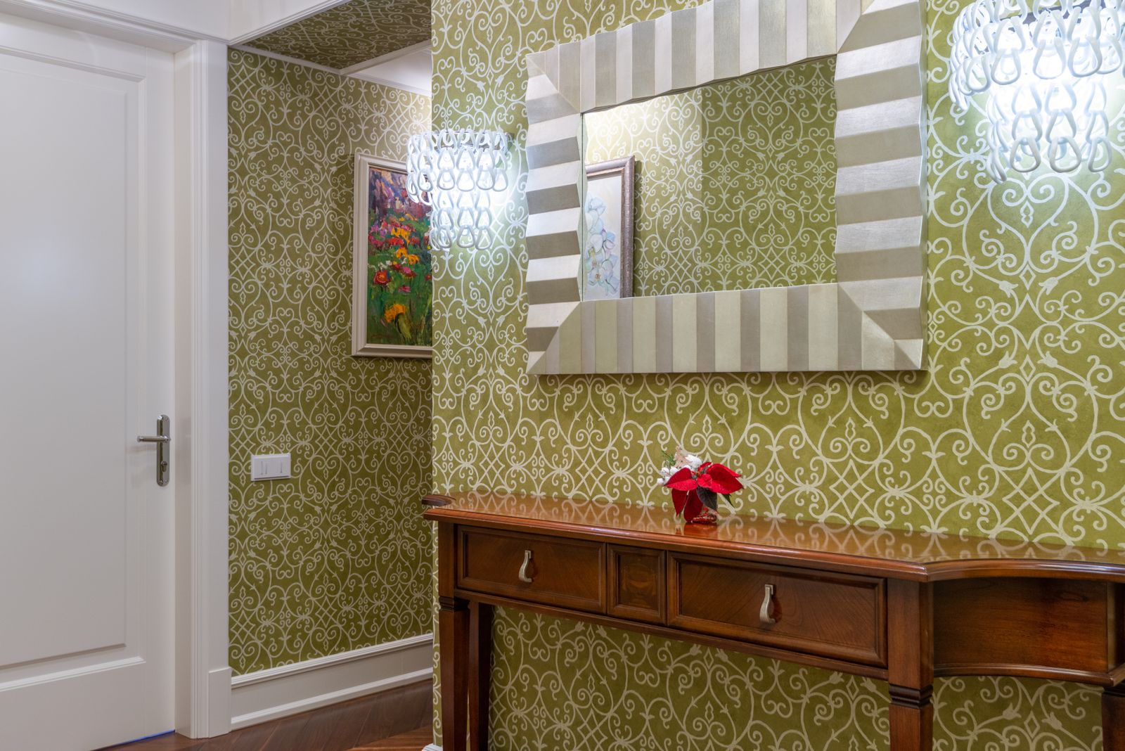 hallway with ornate wallpaper, wooden console table, and decorative mirror, landscape