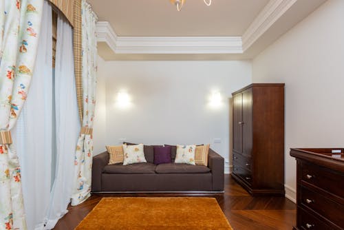 A Wooden Cabinet Near the Couch with Throw Pillows