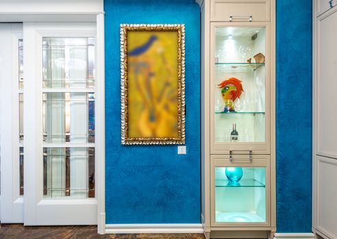 A bright contemporary room featuring a blue wall, sliding door, and colorful artwork.