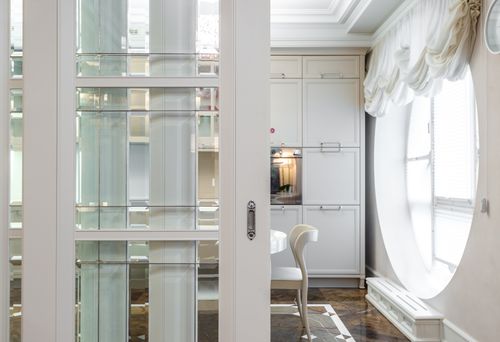 Free A stylish dining area featuring white furniture and a round window, exuding luxury. Stock Photo
