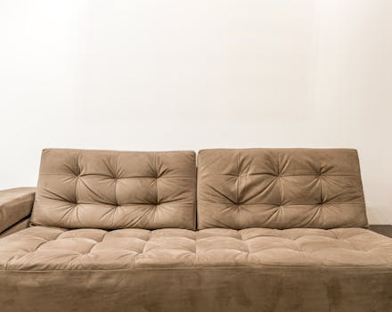Comfortable brown couch with tufted design in contemporary living room setting.