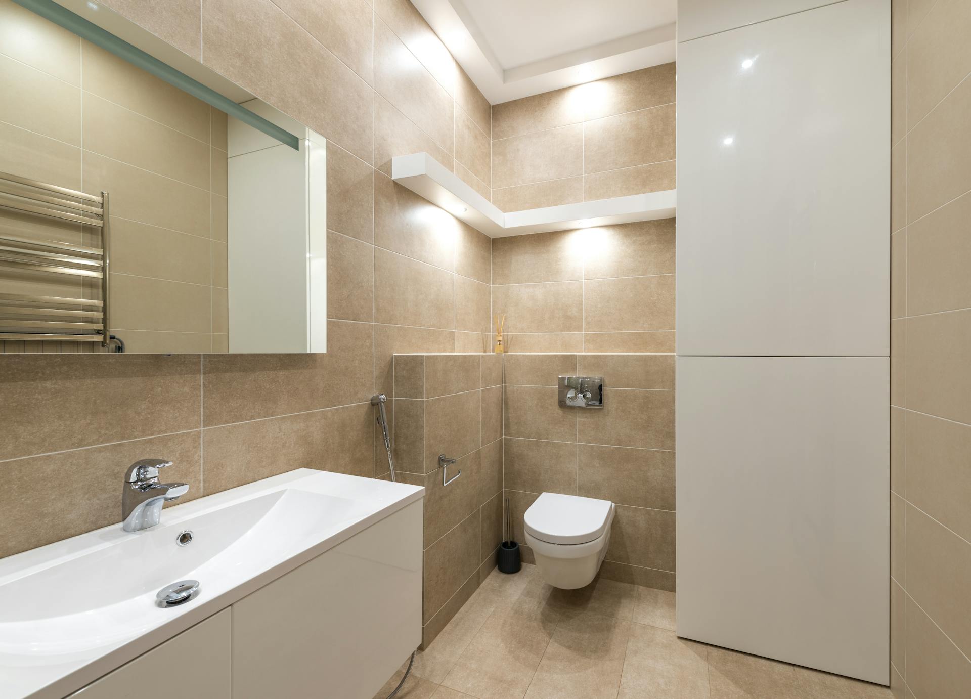 Elegant bathroom interior with modern fixtures, neutral tones, and ample lighting.