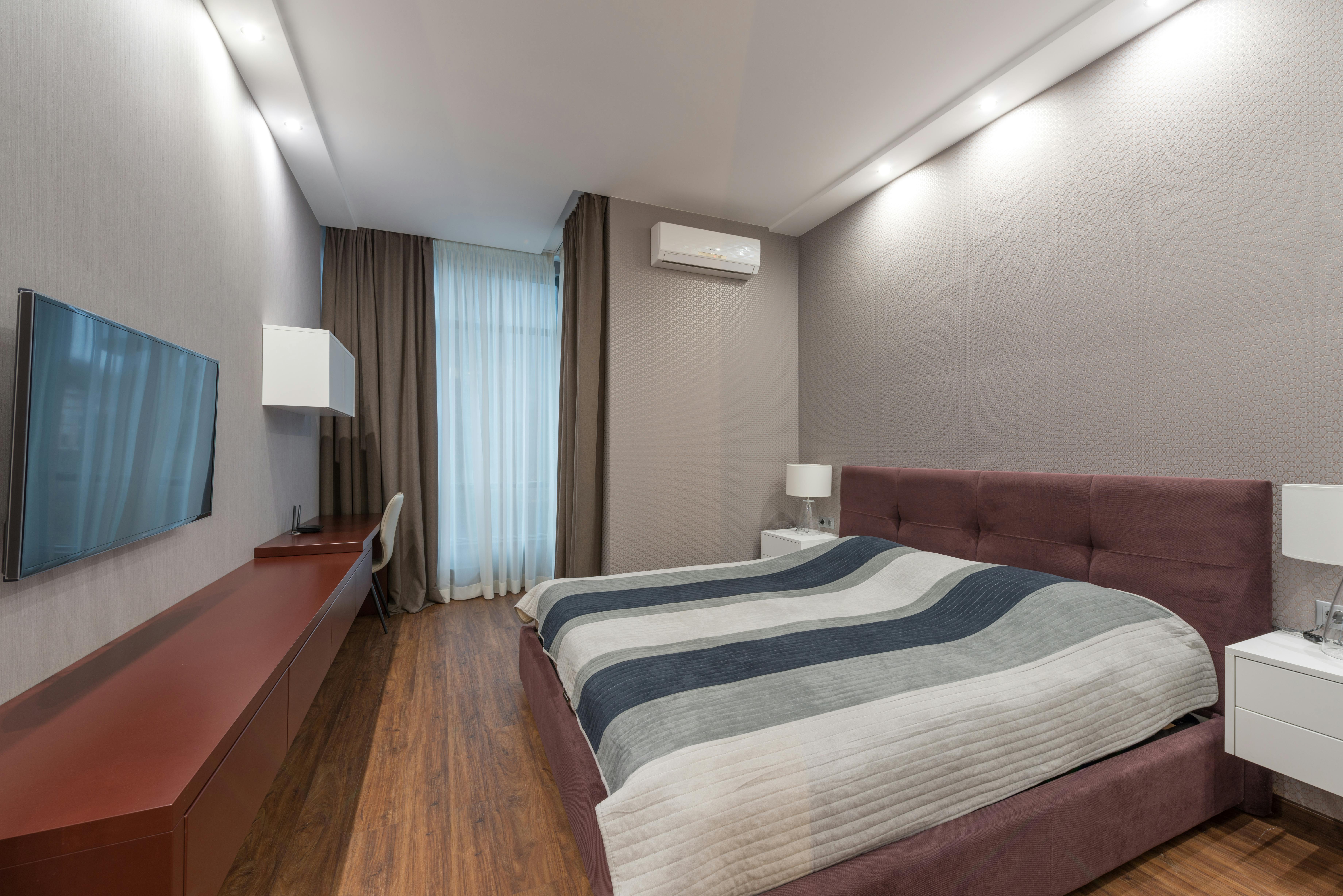 Elegant hotel room interior with a comfortable bed, modern furnishings, and a sleek design.