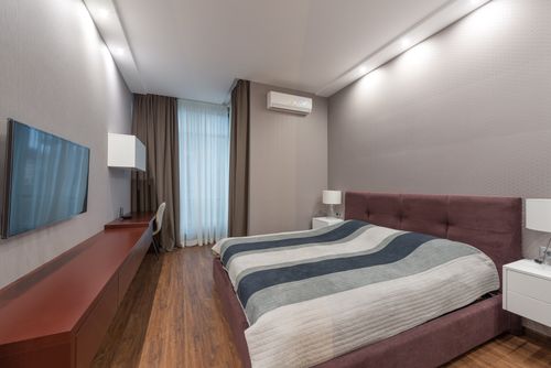 Free Elegant hotel room interior with a comfortable bed, modern furnishings, and a sleek design. Stock Photo