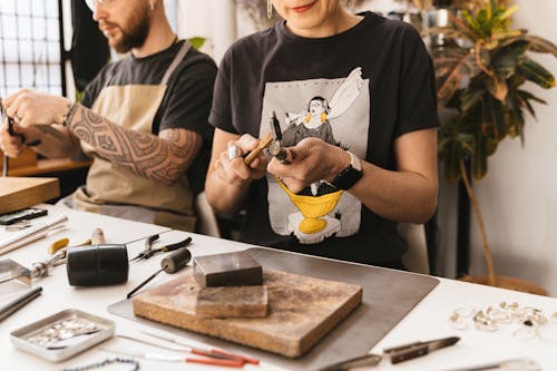 A Person Holding a Steel Tool and a Wooden Tool