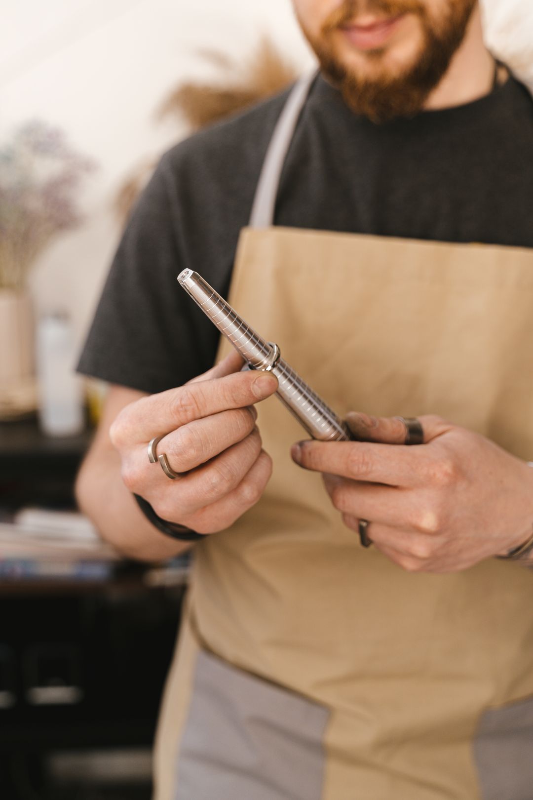 how to care for a tungsten ring: jeweler holding a plain band on a mandrel, FoundryCut