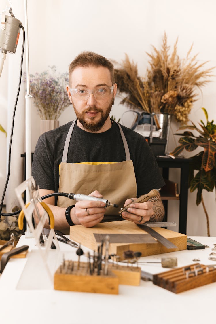 Portrait Of S Jeweller In A Studio With Polishing And Drilling Tools And Dry Plants In Background