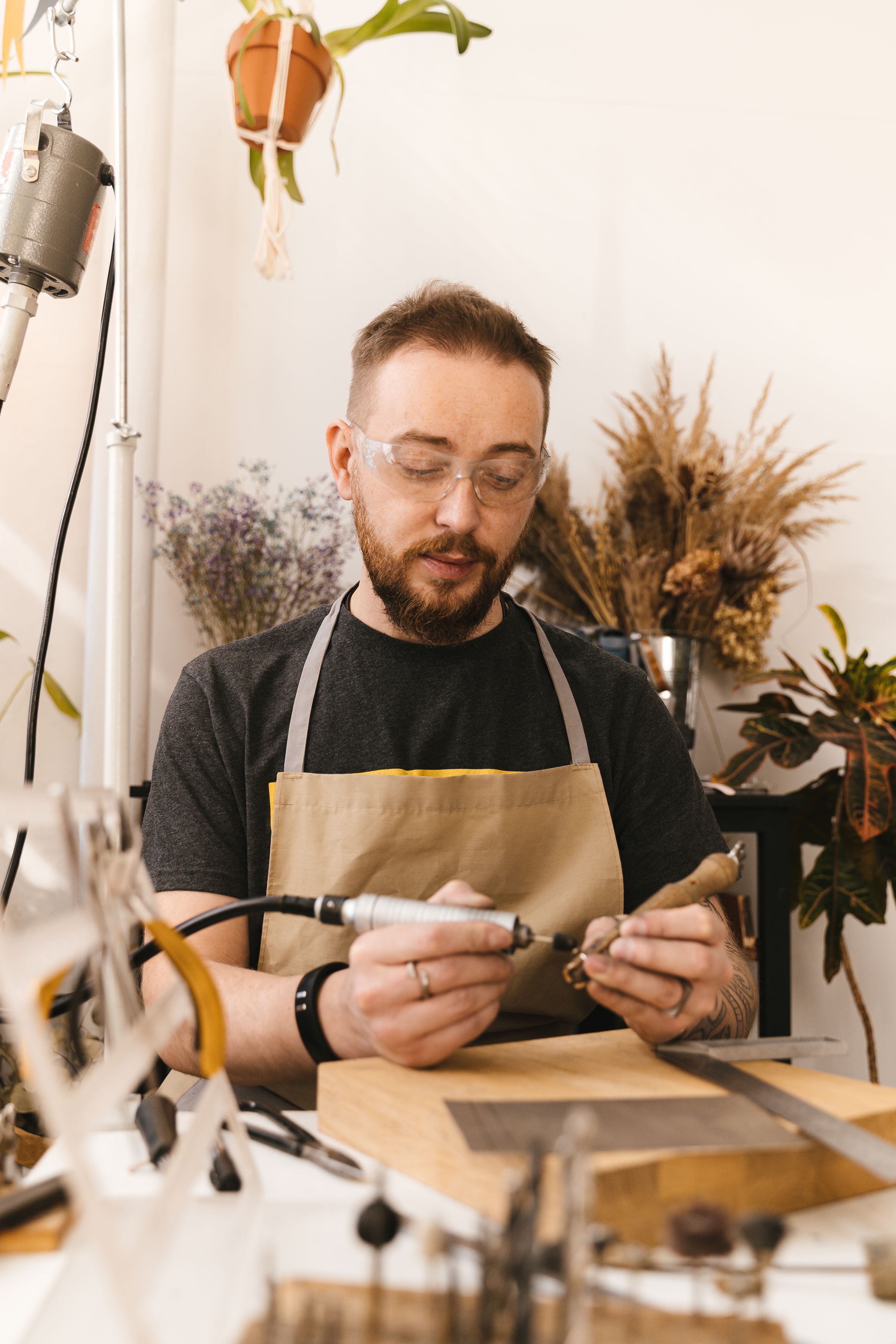Male artisan actively working with precision tools at a workshop bench