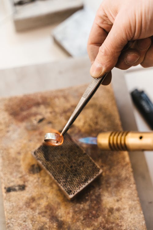 A Person Putting a Metal Ring on Fire