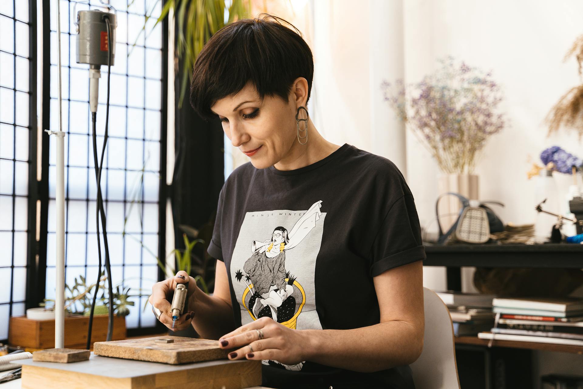 A Woman Holding a Torch Heating a Steel on a  Board