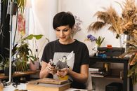 Woman in Black Shirt Holding Blowtorch in Front of Work Desk