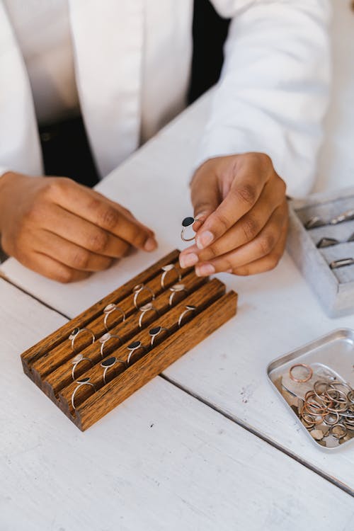 Hands Arranging Rings on Display