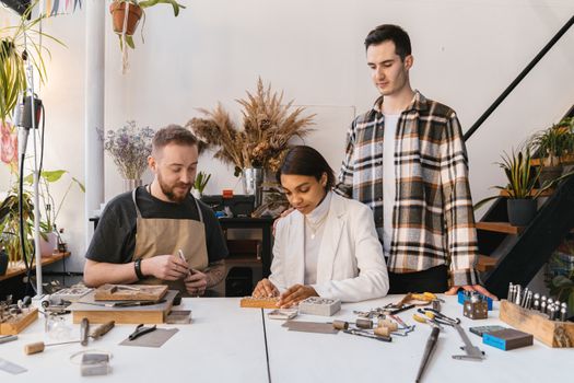 Woman Visiting Jewellers Studio with Fiance and Looking at Rings