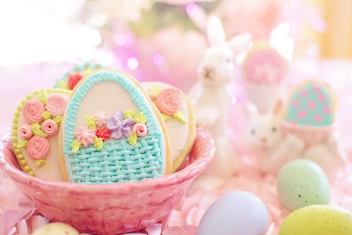Free A delightful Easter-themed image featuring decorated cookies in a basket with bunnies and pastel eggs. Stock Photo