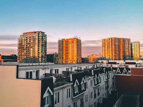 Captivating view of a modern city skyline with residential buildings illuminated by sunrise.